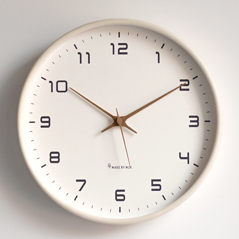 White wall clock with black numbers and brown hands on a light gray background
