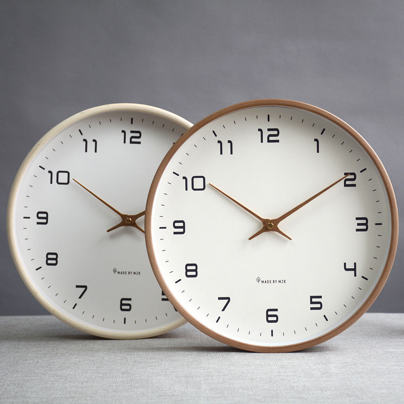 Two wall clocks with white faces and brown wooden frames on a gray surface.