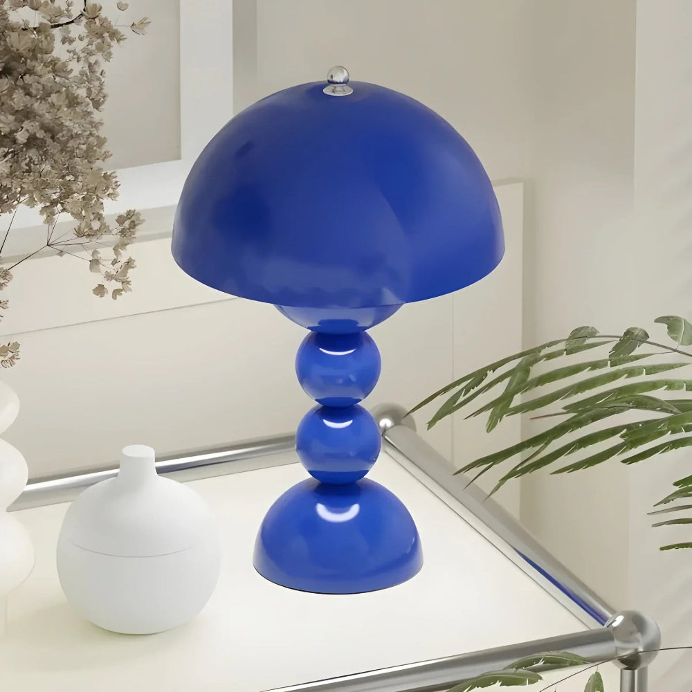 Blue table lamp on a white surface with decorative elements in the background