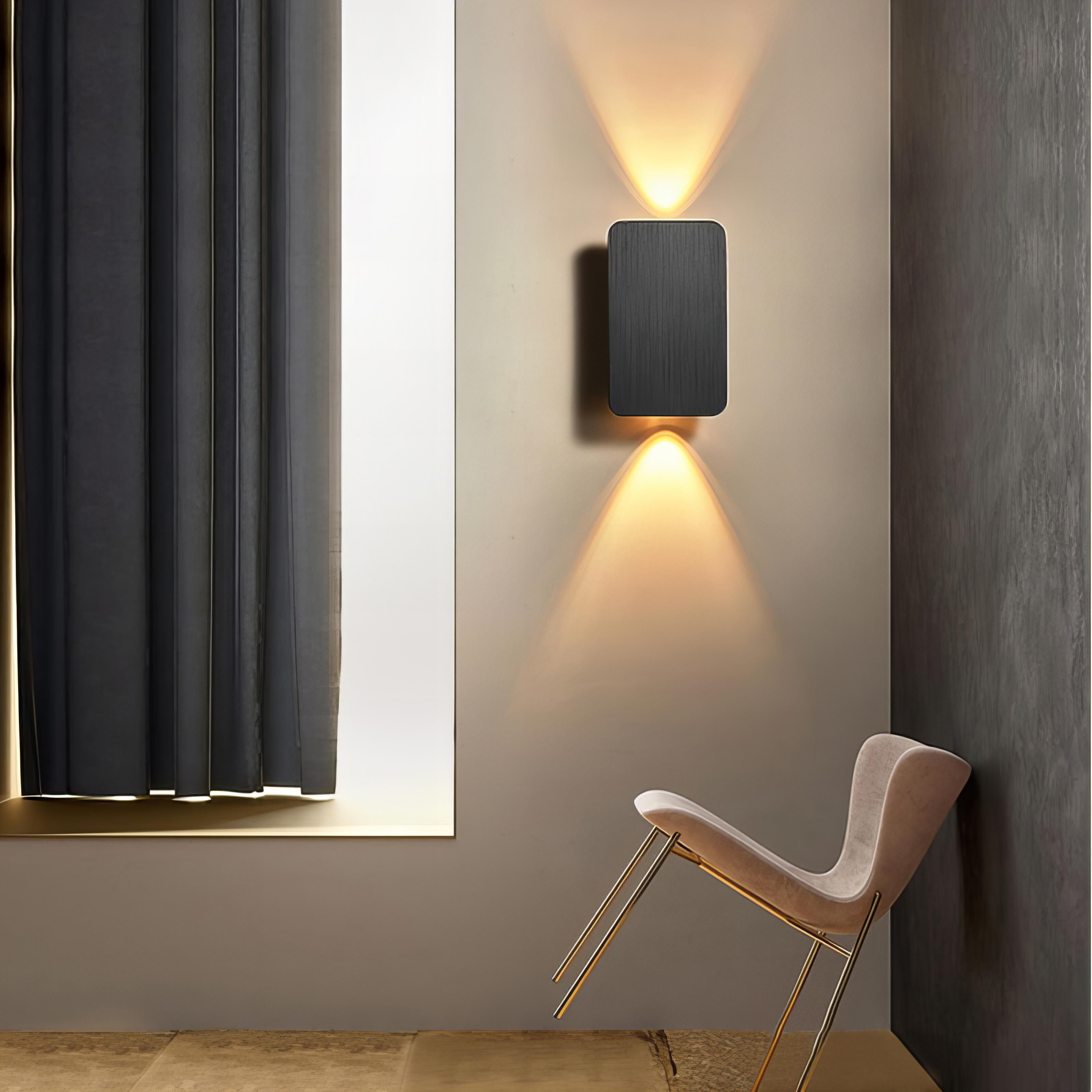 Modern wall lights on a neutral wall with a chair in the foreground