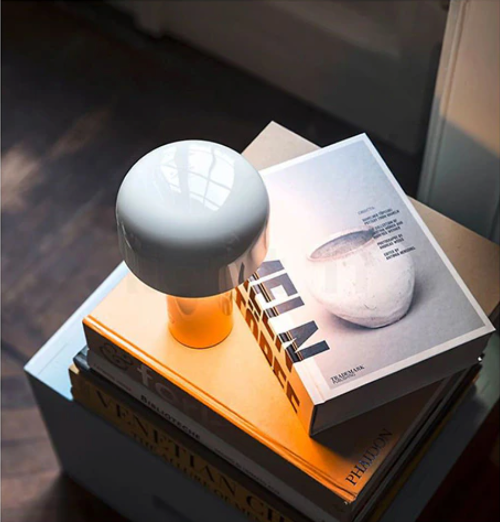 White spherical object on a stack of books with a magazine featuring a similar object.