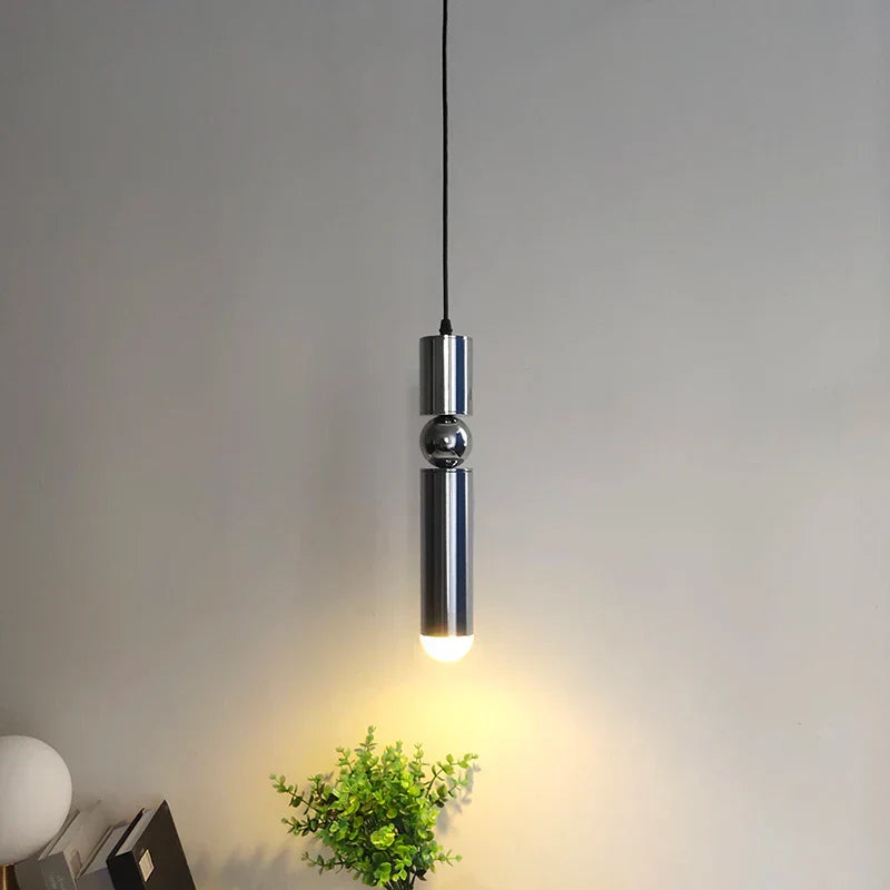 Modern pendant light fixture on a neutral background with a plant