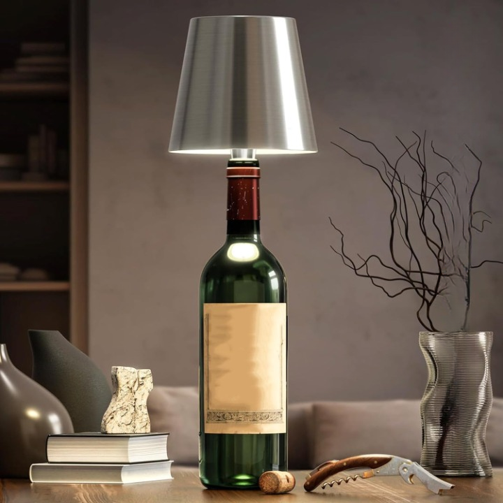 Wine bottle lamp with a metallic shade on a table in a room setting.