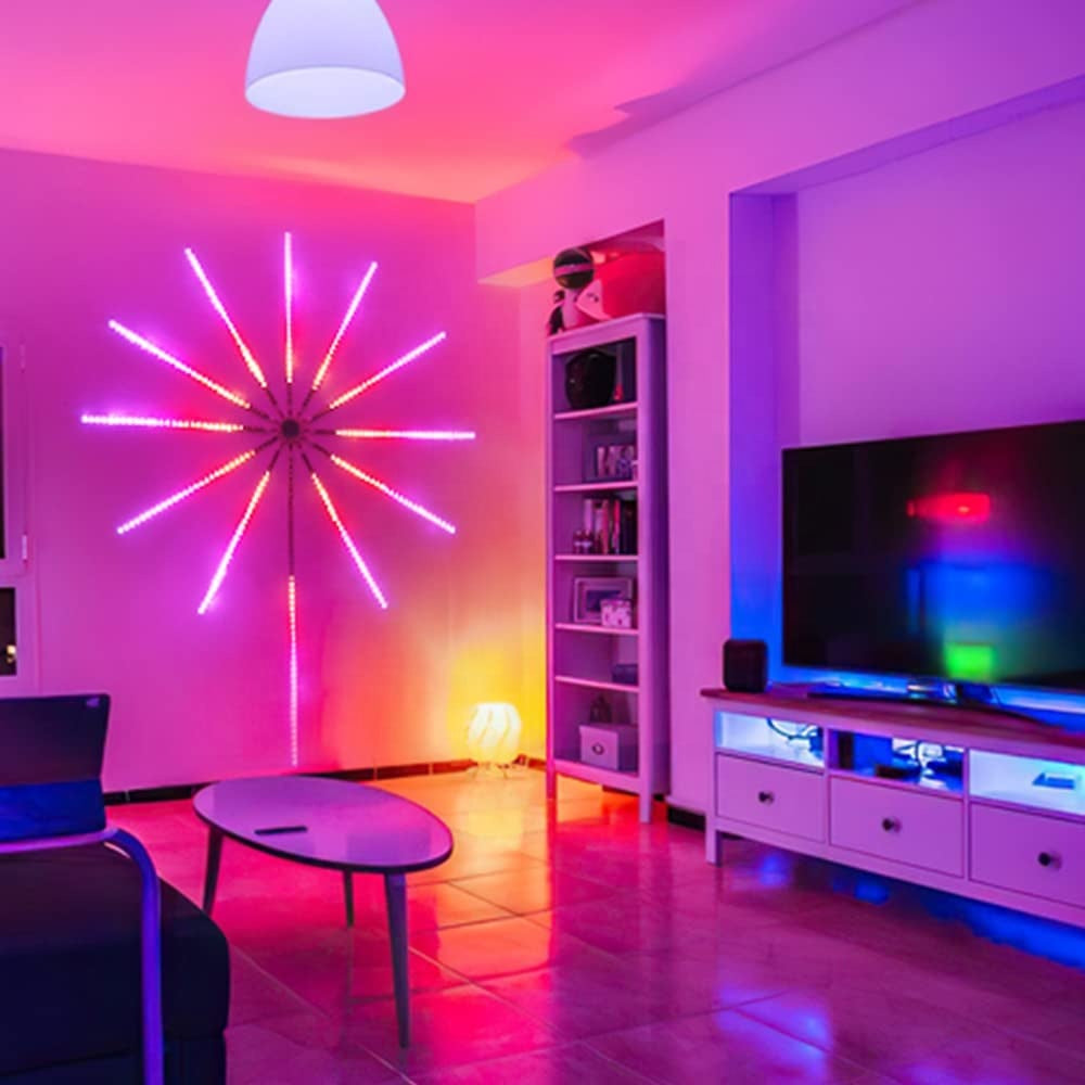 Modern living room with neon wall light, TV, and shelves.