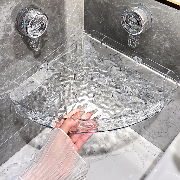 Clear corner shower caddy held by a hand in a bathroom setting