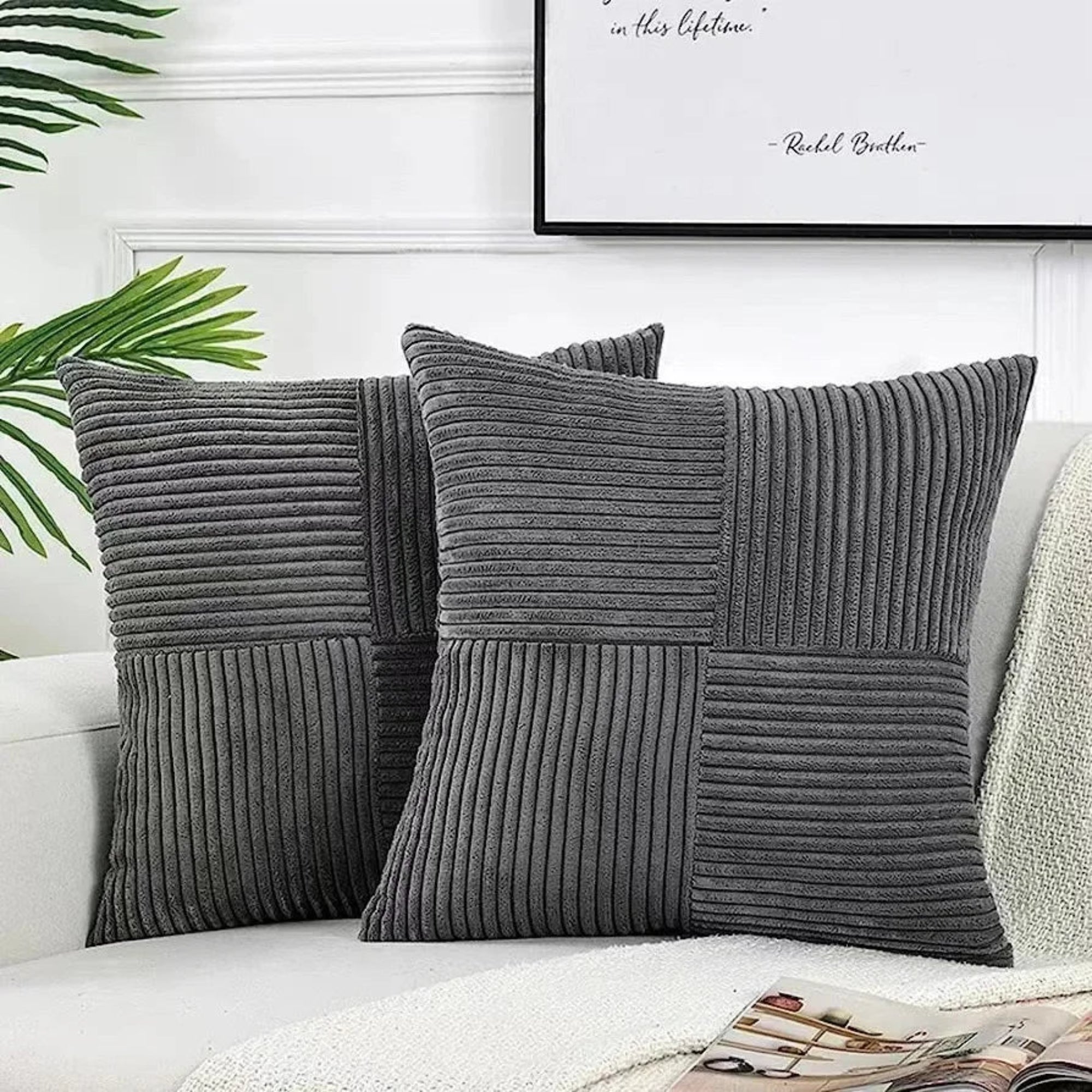 Gray textured throw pillows on a sofa with a framed quote in the background.