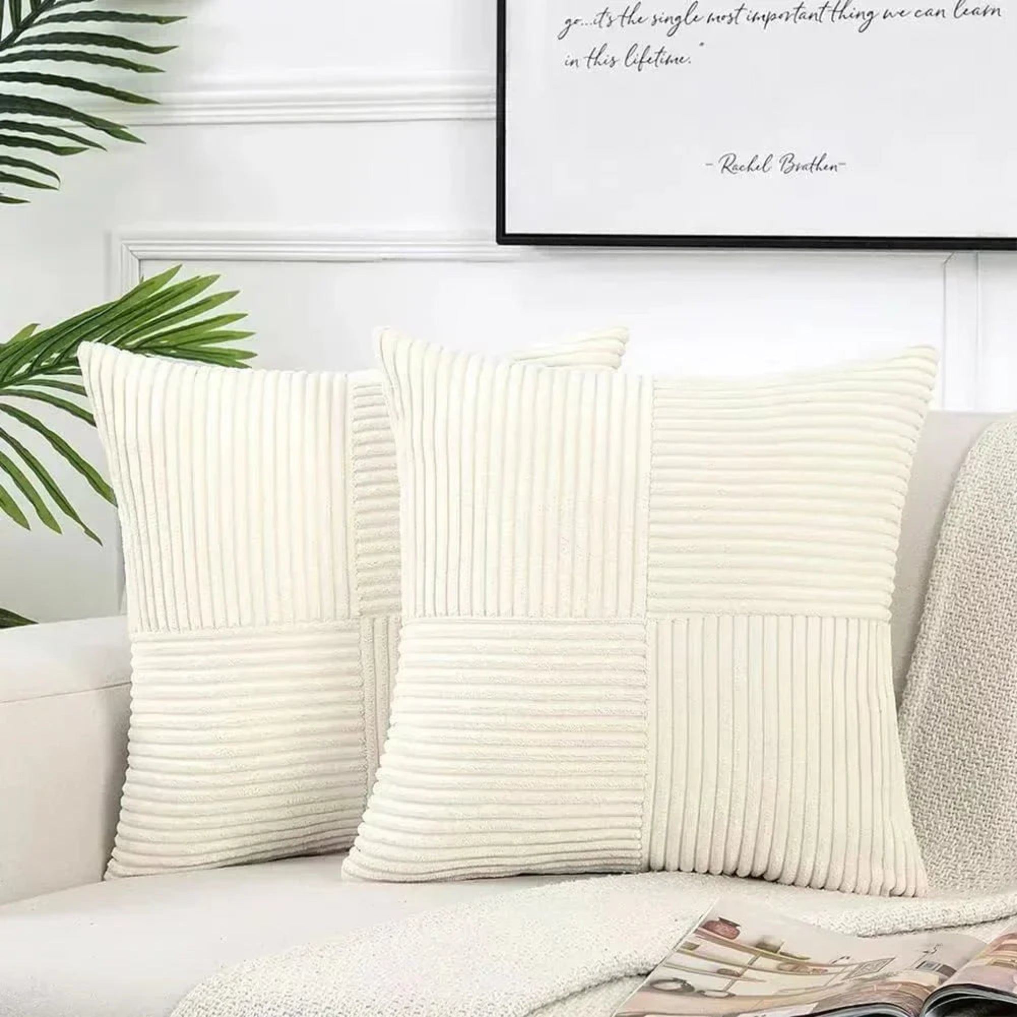 Two cream-colored textured pillows on a sofa with a framed quote in the background.