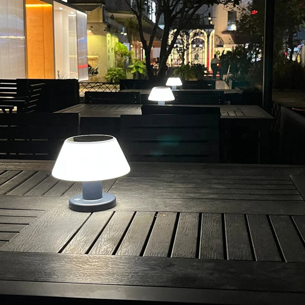White outdoor lamp on a wooden table with a cityscape background