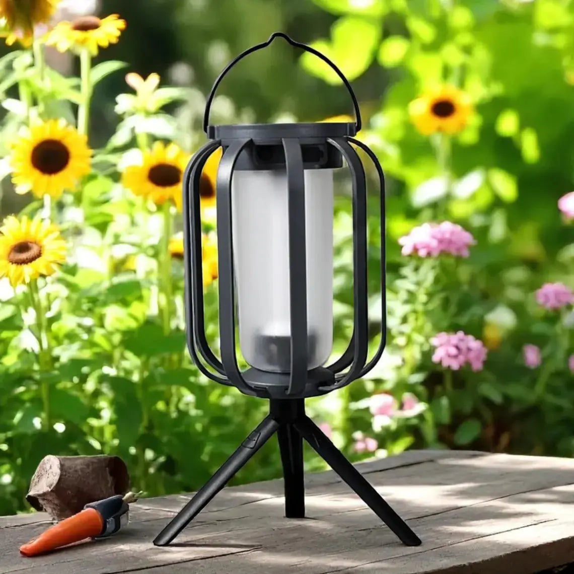 Black lantern on a wooden surface with flowers in the background