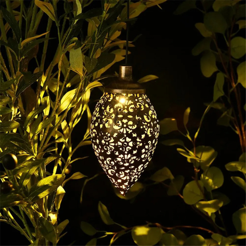 Decorative solar light hanging among green leaves at night