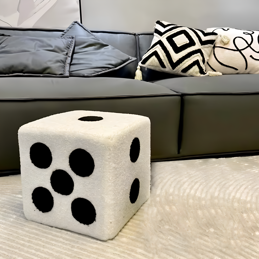 White dice-shaped ottoman with black spots on a living room floor.