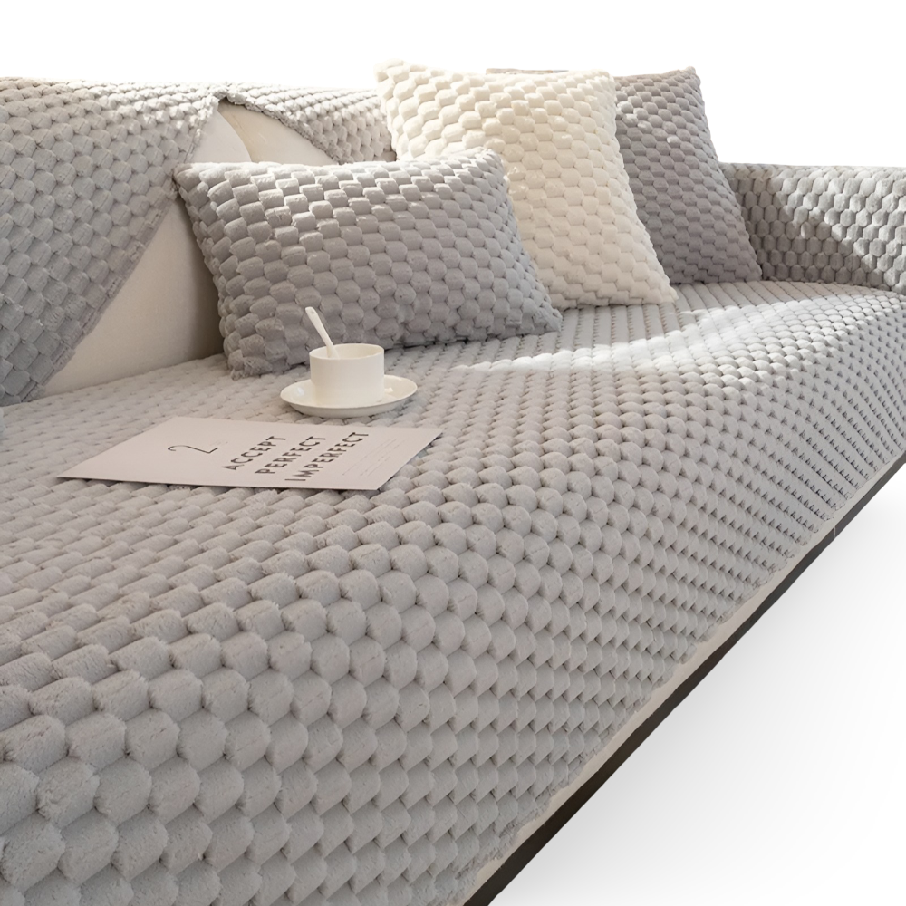 Gray textured sofa with cushions and a small table on a white background