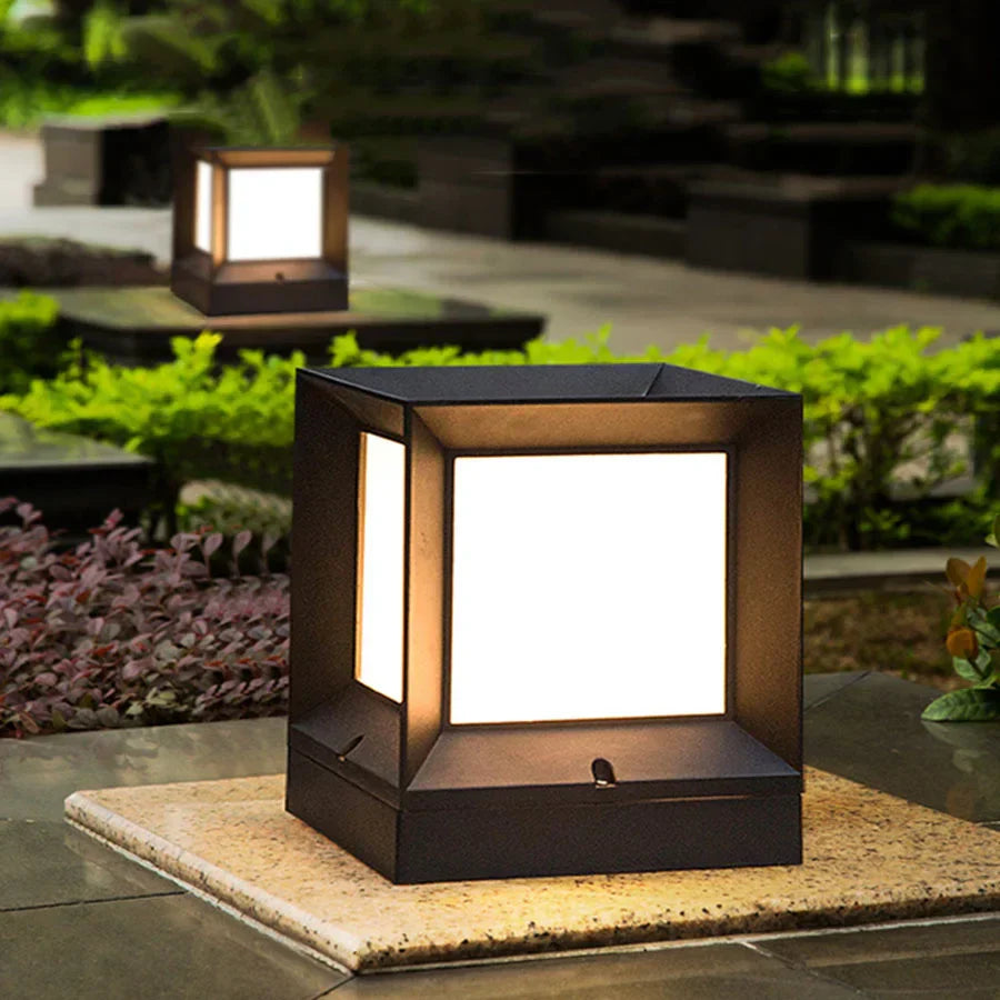 Square outdoor light fixture on a patio with garden background