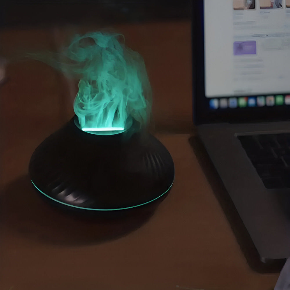 Glowing green object on a black stand next to a laptop on a desk