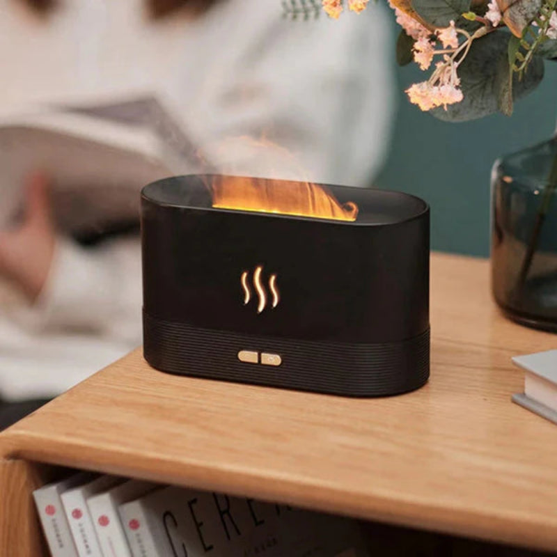 Black flame-shaped diffuser on a wooden surface with a blurred background