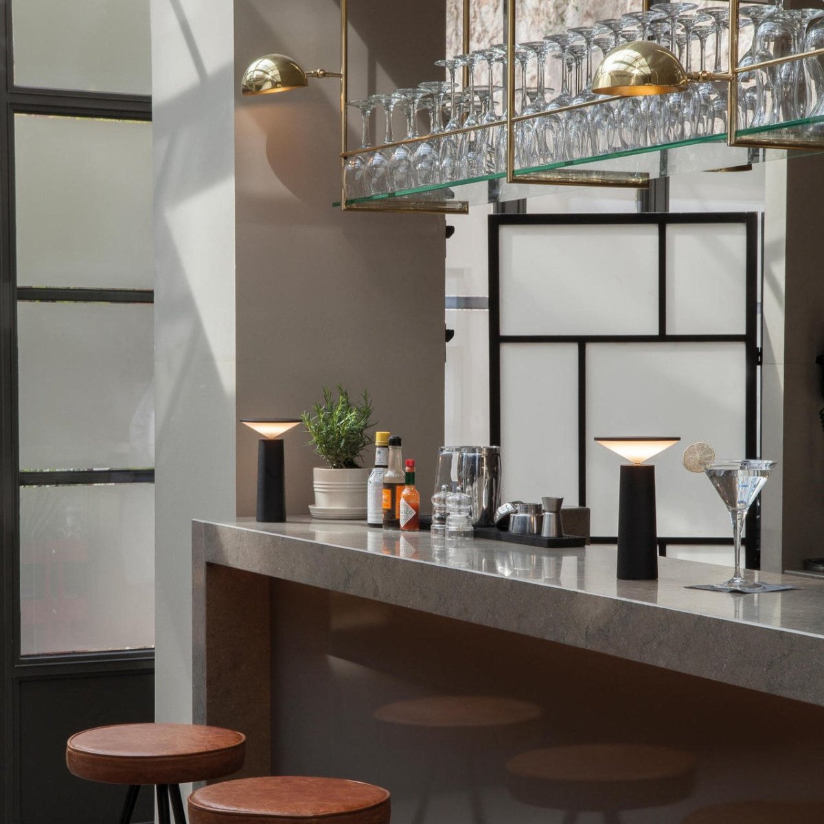 Modern bar setup with marble countertop, stools, and decorative elements.