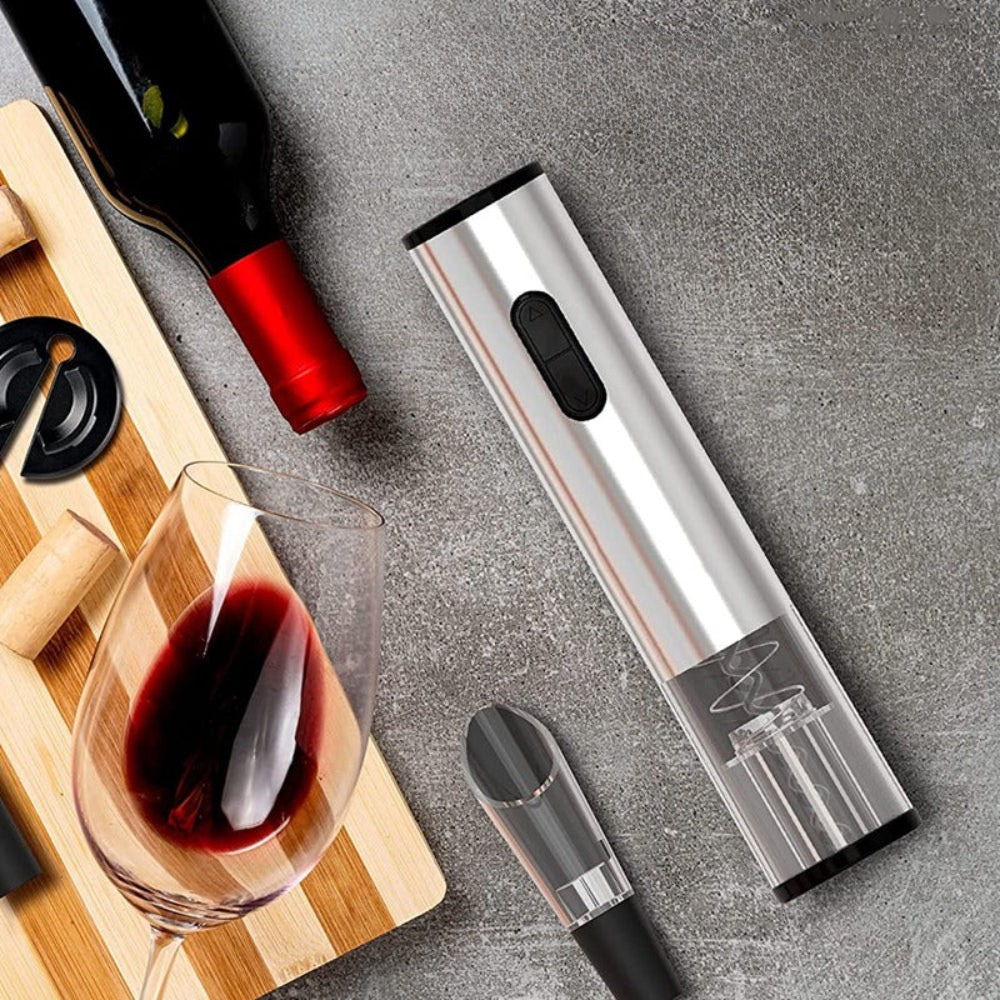 Electric wine opener with a bottle, glass, and cork on a gray surface