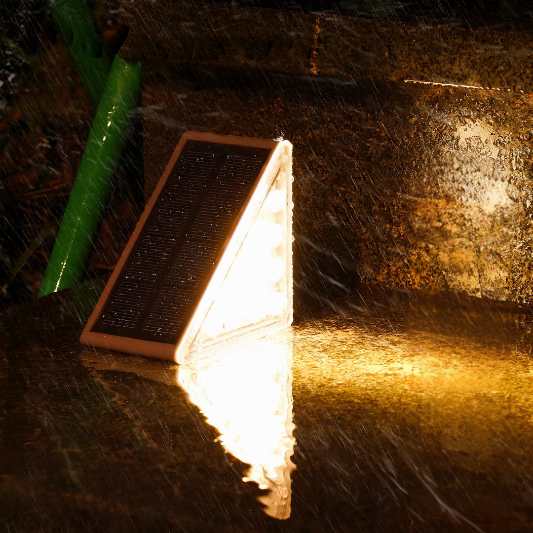 Solar-powered outdoor light fixture on a stone surface at night