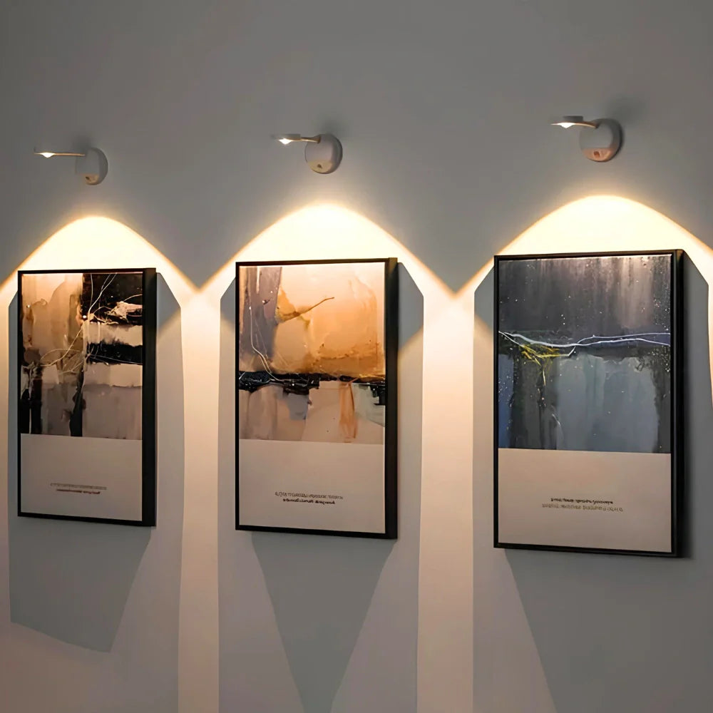 Three framed artworks on a wall with soft lighting