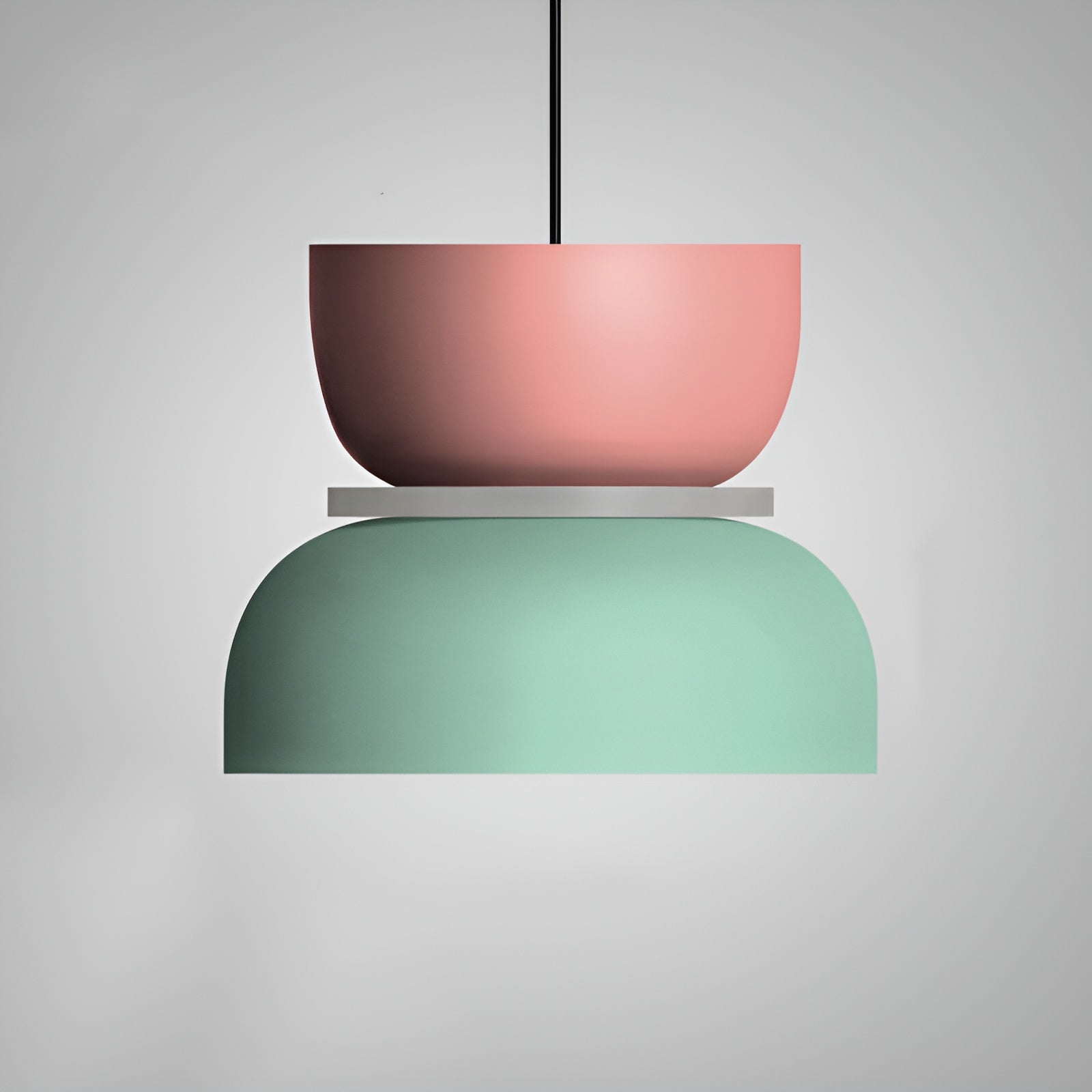 Two-layered pendant light with pink upper shade and green lower shade on a gray background