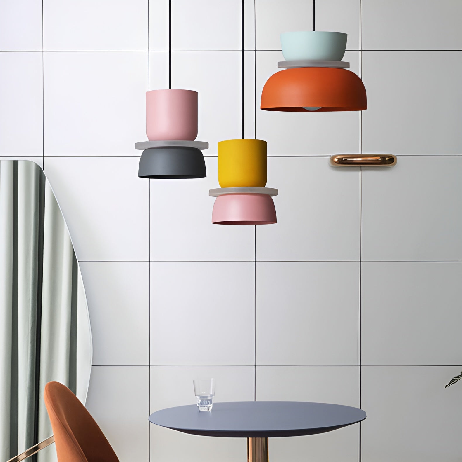 Colorful pendant lights hanging above a table in a modern kitchen.