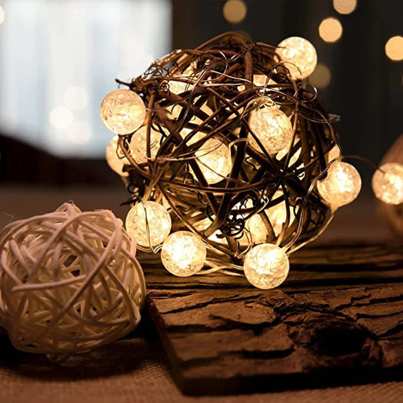 String lights wrapped in rattan on a wooden surface with blurred lights in the background