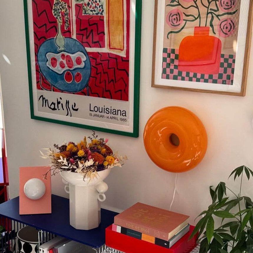 Colorful artwork on a wall with decorative items below