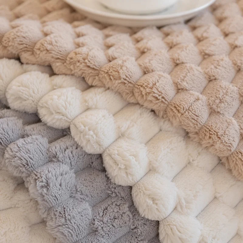 Textured woven mat with pom-pom pattern in neutral colors.