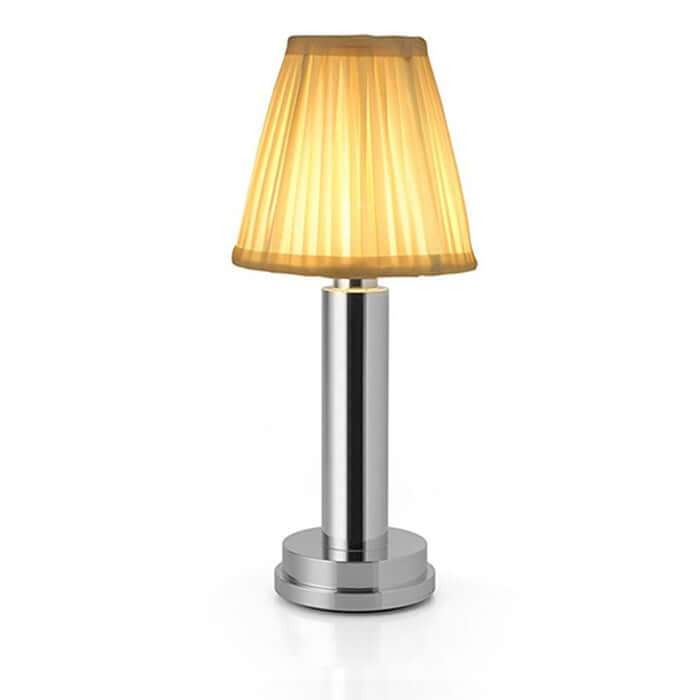 Table lamp with a gold shade and silver base on a white background