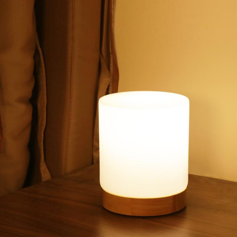 Futuristic cylindrical light on a wooden surface with a warm glow