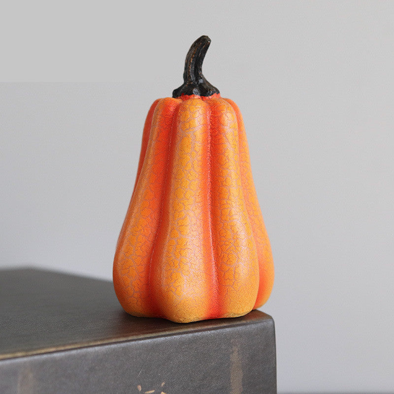Decorative orange and red fruit-like object on a gray surface with a neutral background
