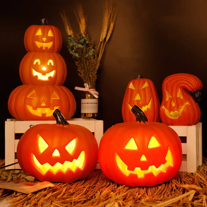 Decorative pumpkins with carved faces on a wooden crate against a dark background