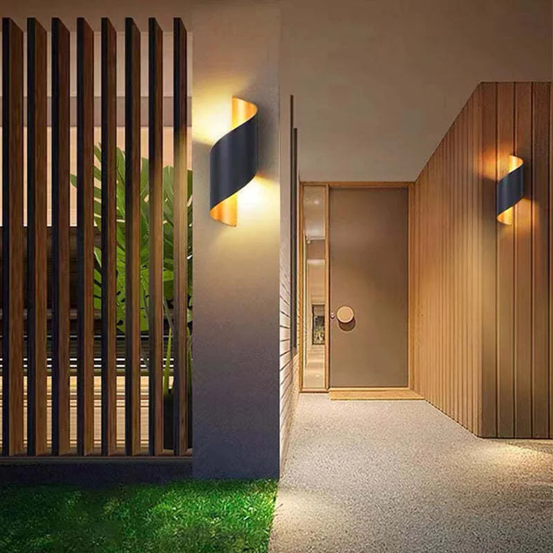 Modern outdoor setting with wall lights, wooden slats, and a door.
