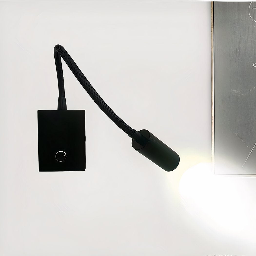 Modern black wall-mounted light fixture on a white wall.
