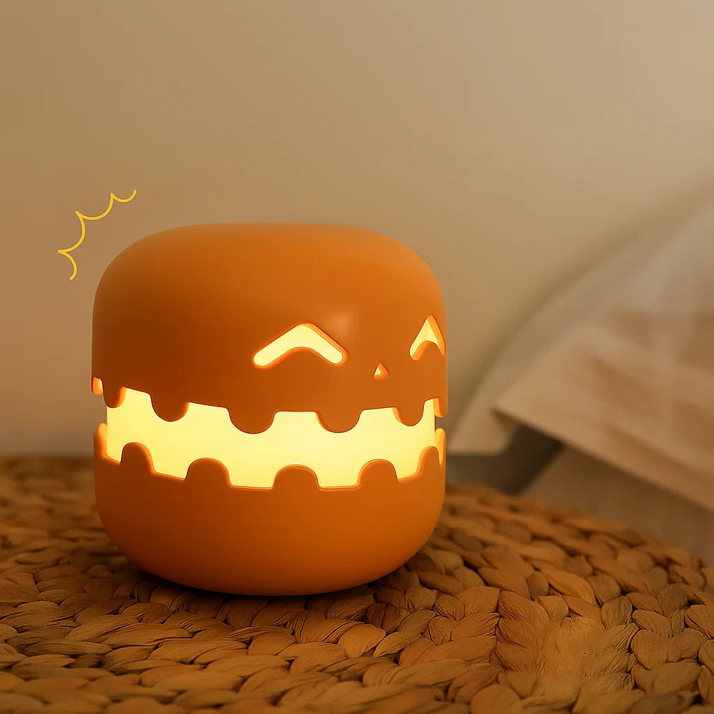 Ceramic jack-o'-lantern night light on a woven surface with a blurred background