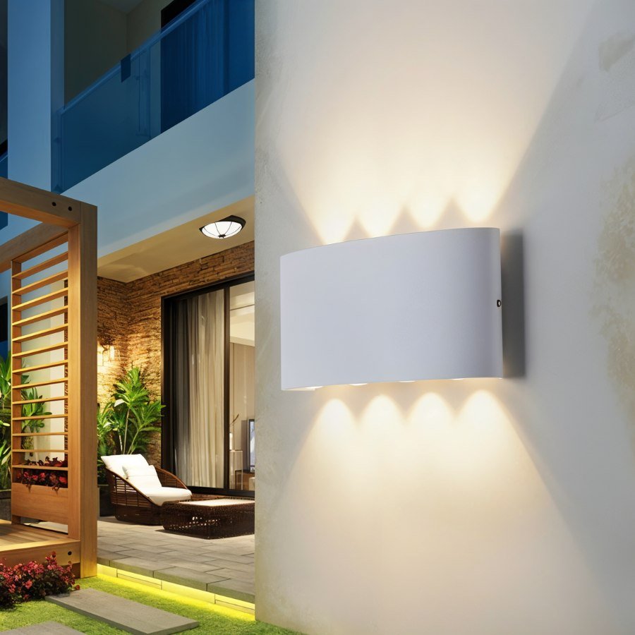 Modern outdoor wall light fixture on a building exterior with a view into a patio area.