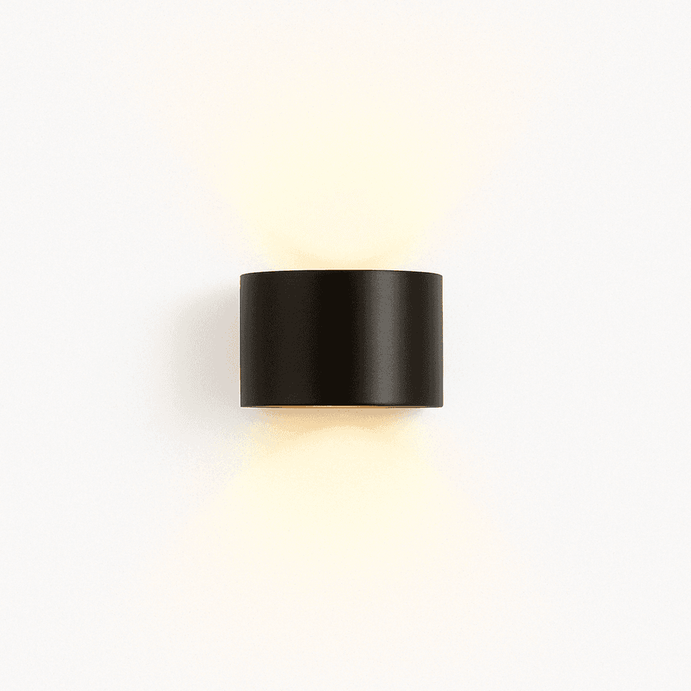 Black cylindrical wall light fixture on a white background