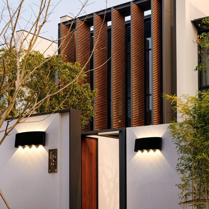 Modern house exterior with wooden slat design and wall-mounted lights.