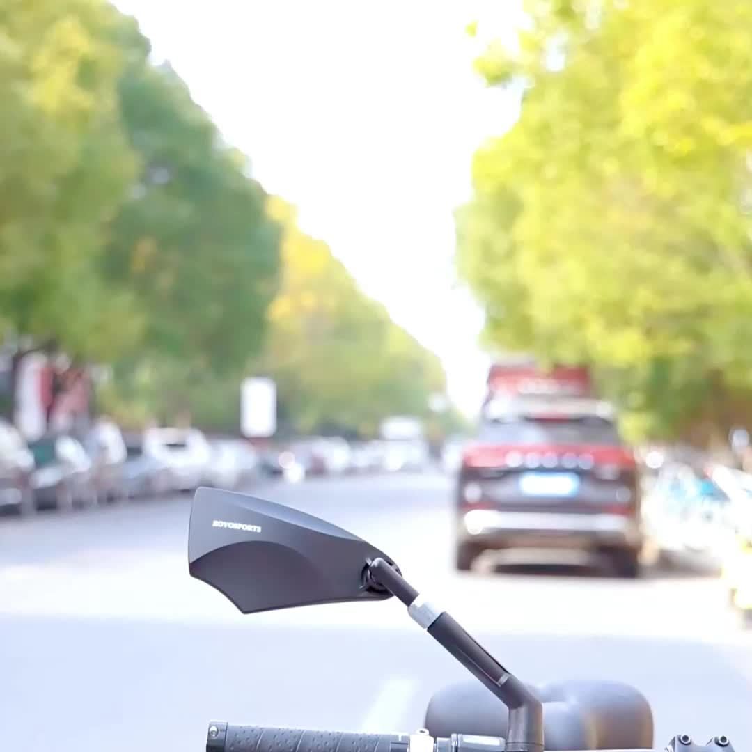 Motorcycle mirror with a blurred street scene in the background