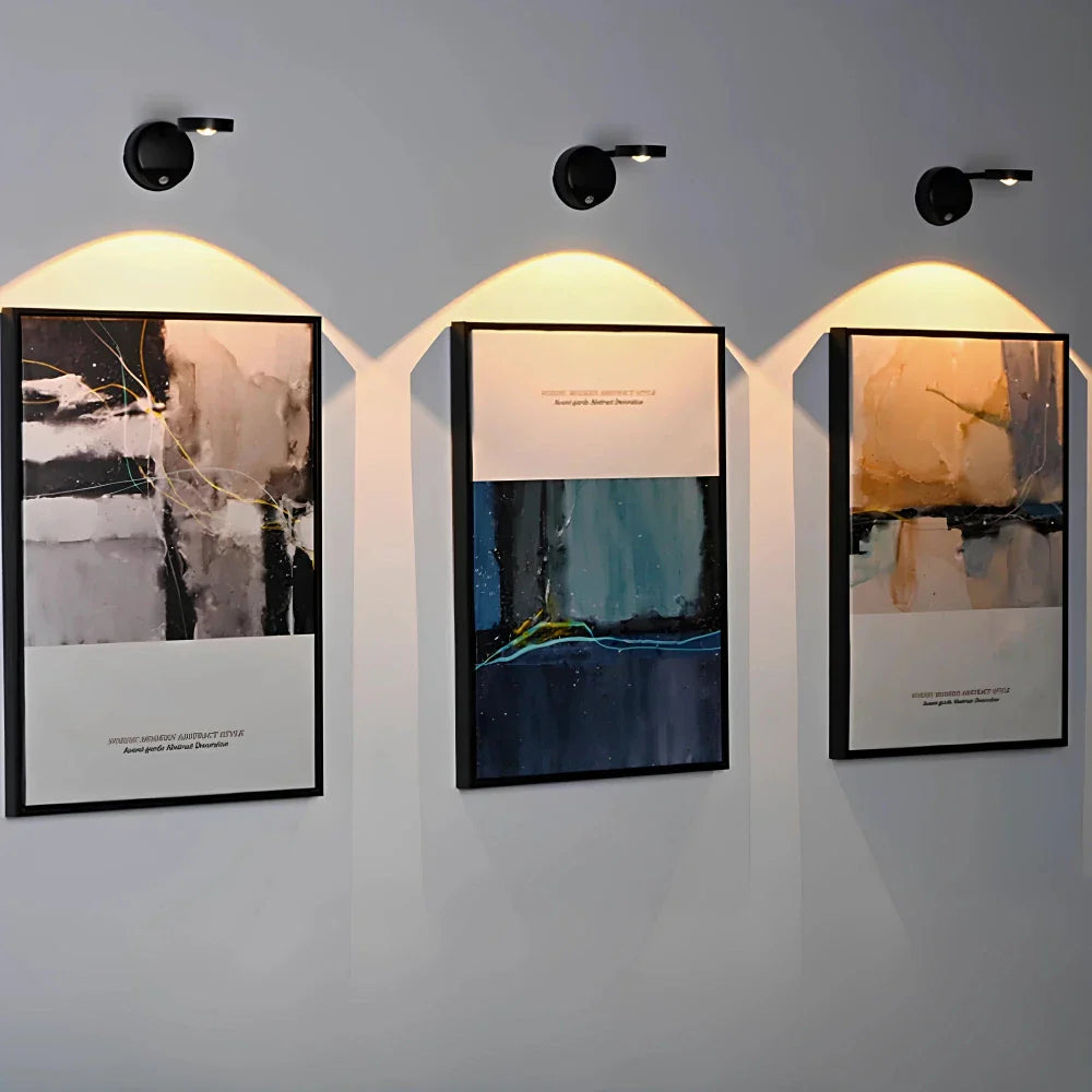 Three framed artworks on a wall with soft lighting