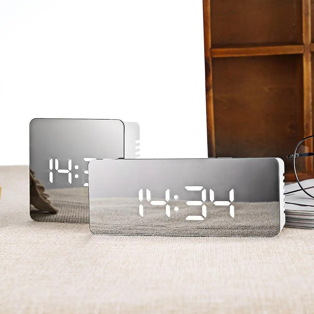 Two digital clocks with LED display on a surface.