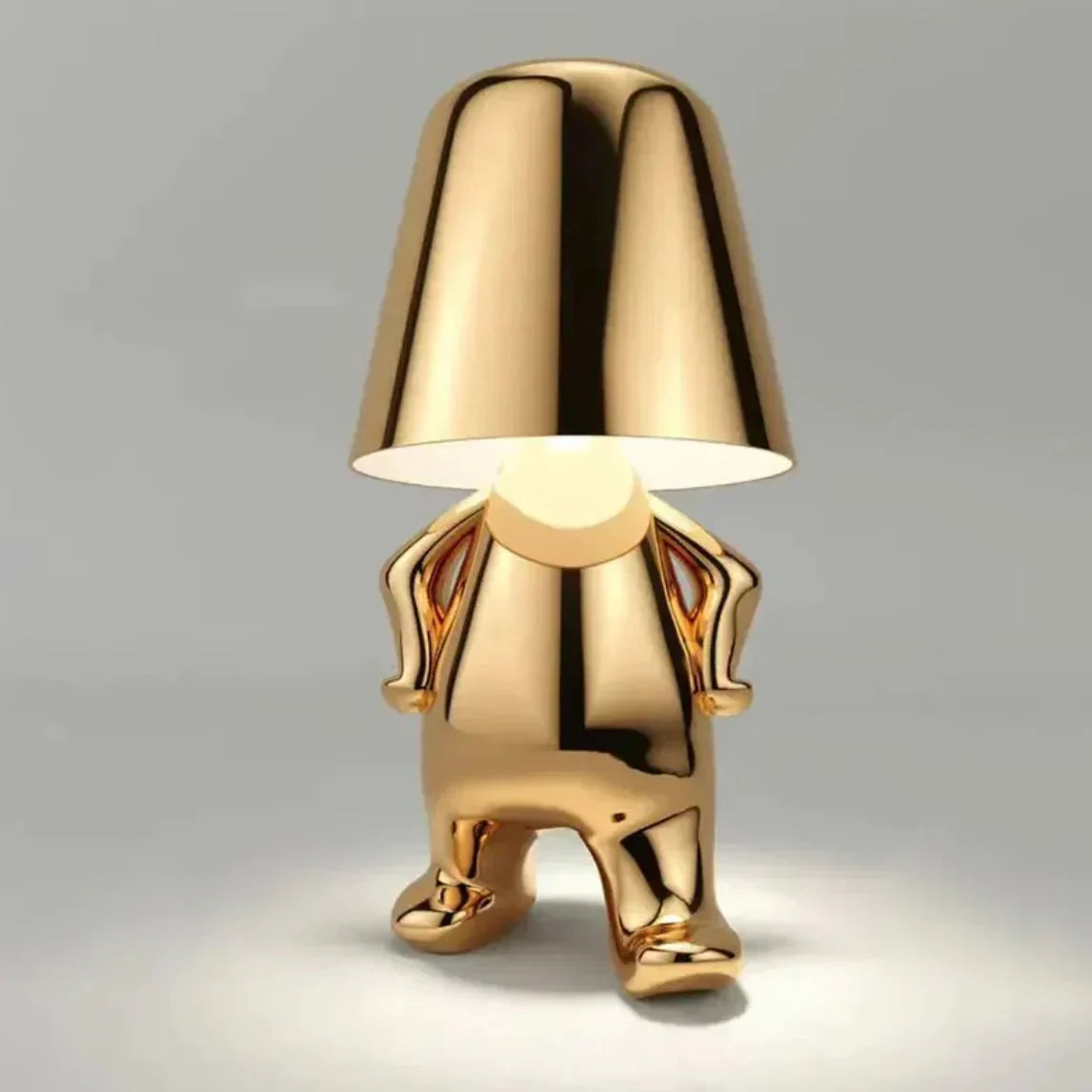 Gold-colored gnome-shaped lamp on a gray background