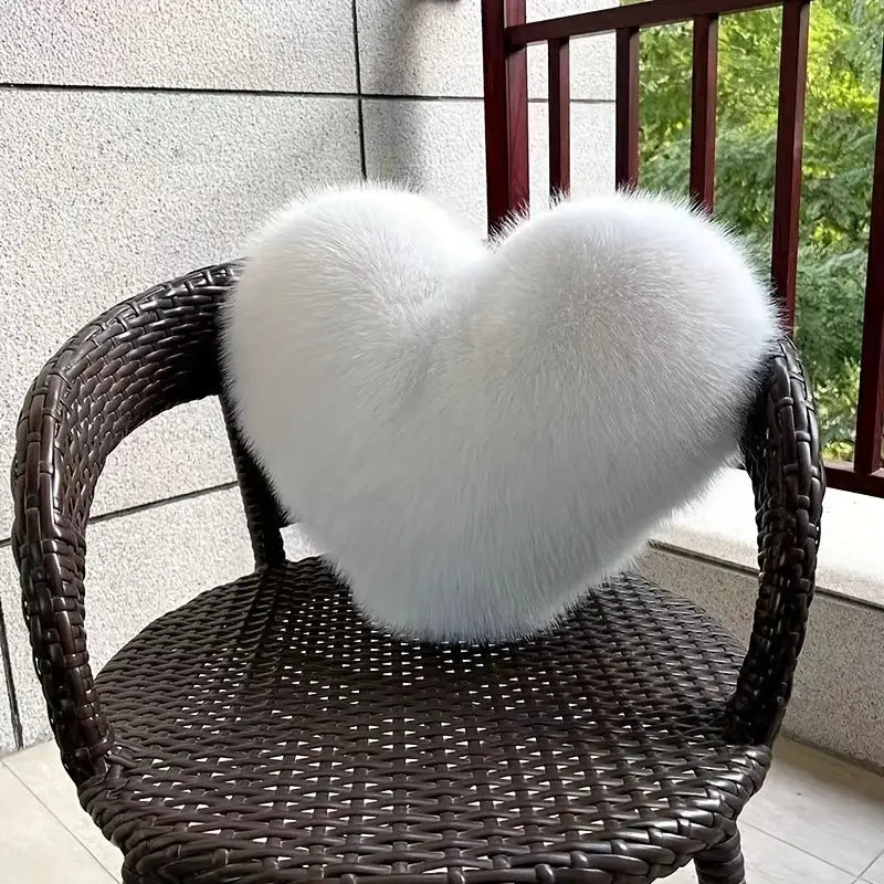 White fluffy heart-shaped object on a wicker chair with a blurred outdoor background