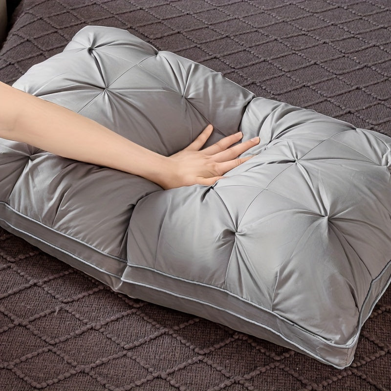 Gray comforter draped over a person lying on a textured surface
