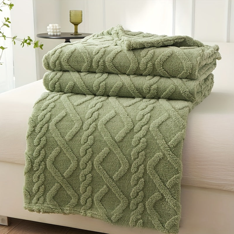 Stack of green textured towels on a white surface with a blurred background