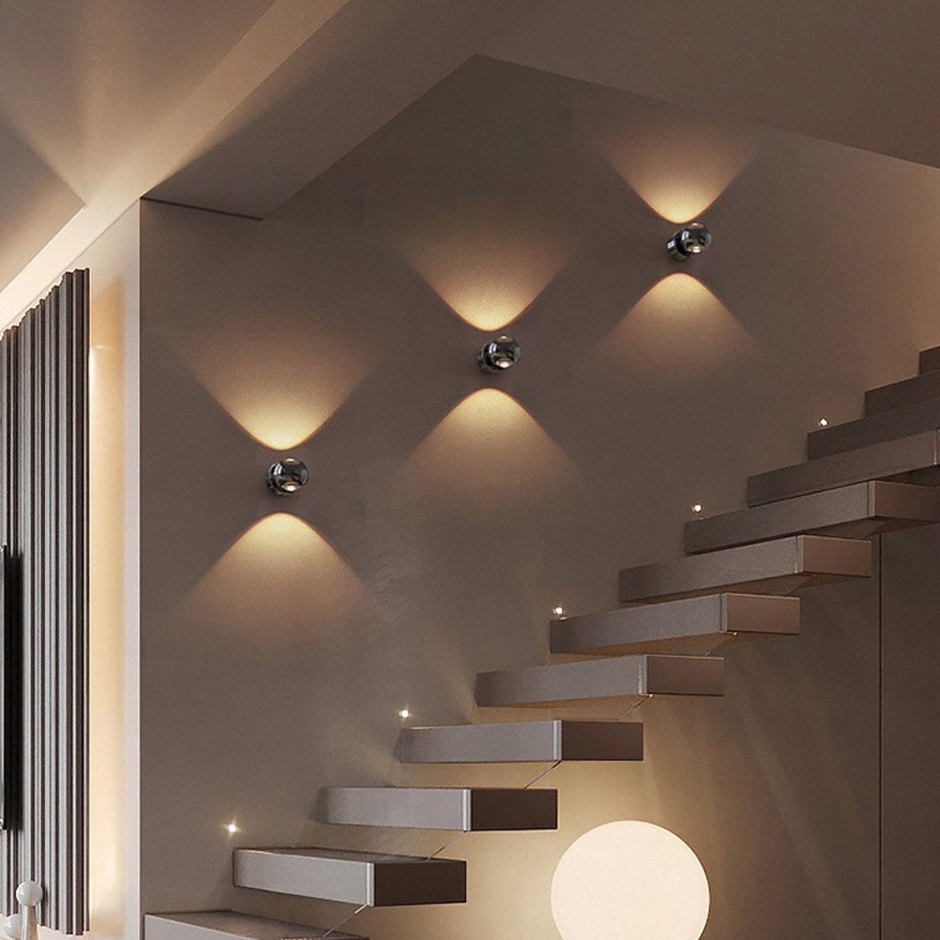 Modern staircase with wall lights in a dimly lit room