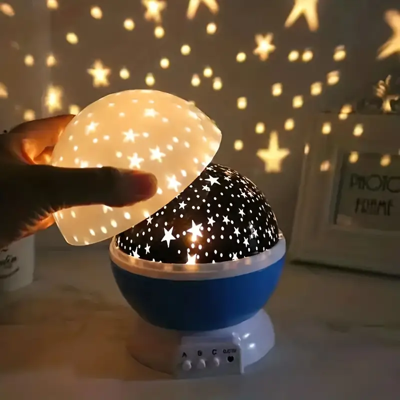 Starry night light projector with glowing stars projected onto a wall.