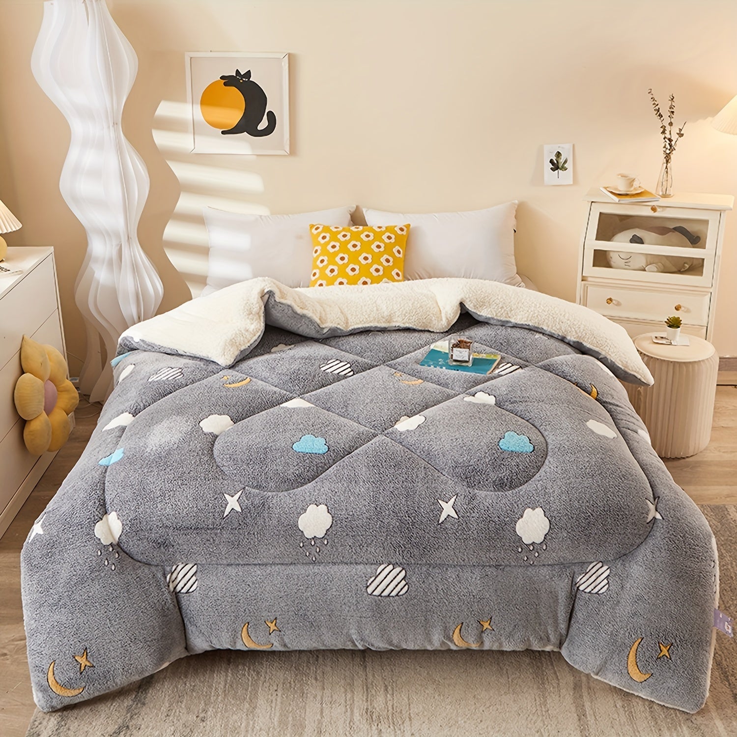 Gray comforter with cloud and star patterns on a bed in a bedroom setting.