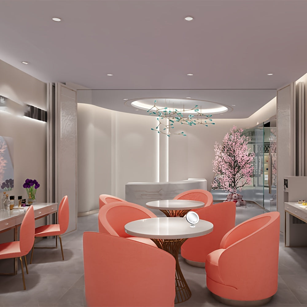 Modern interior design with pink chairs and tables in a well-lit room.