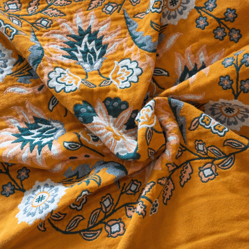 Close-up of orange fabric with intricate floral patterns